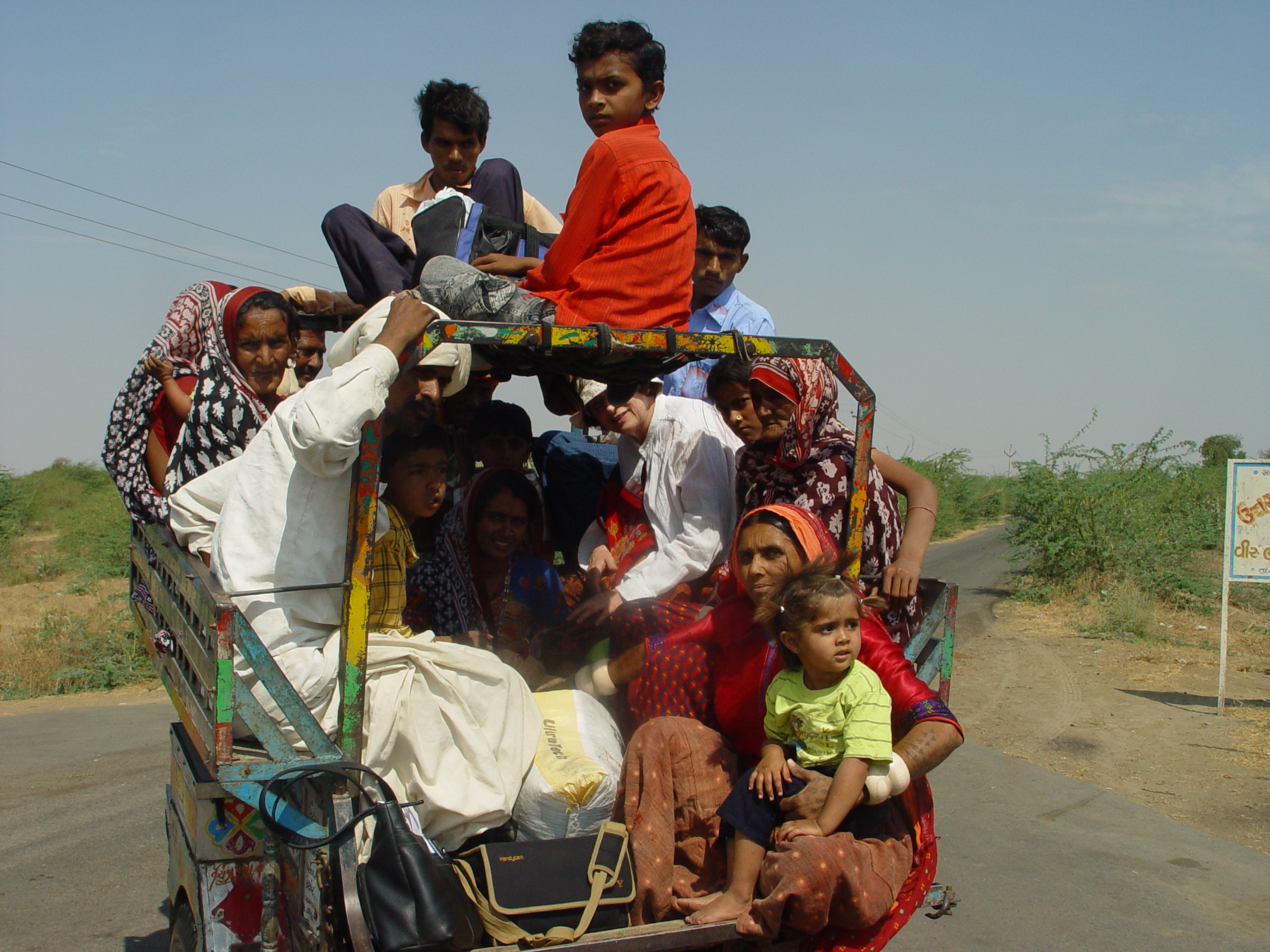 Sheila is squashed into the front in a white shirt, and hanging off the back is Puriben in the red top with her grandchild, en route for a day's work travelling to supervise the work of local embroiderers in the villages she is responsible for.